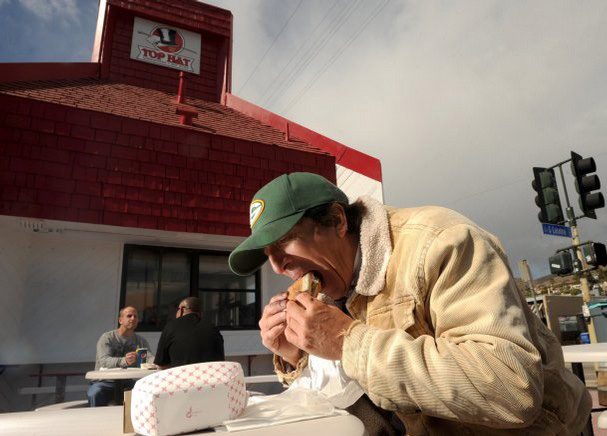 Joe Paz of Ojai bites into a burger at the Top Hat Burger Palace